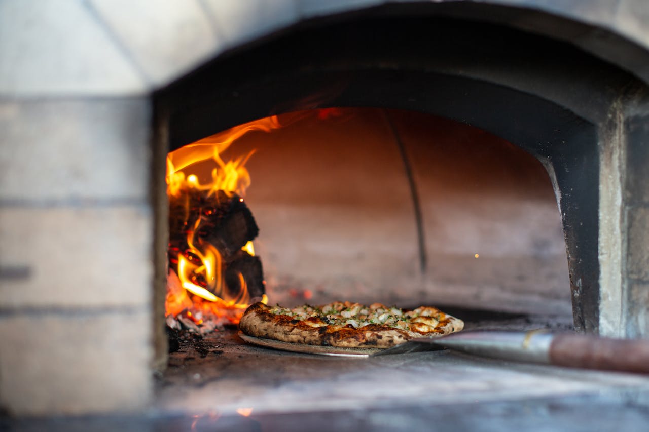 Cuisson artisanale de pizza napolitaine au four à bois